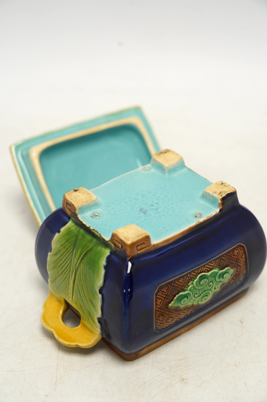 A small Minton majolica box and cover, possibly after a design by Christopher Dresser, 13cm wide. Condition - poor